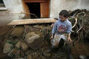 Мальчик, сидящий у разрушенного входа своего дома (г. Деллис, Алжир).
