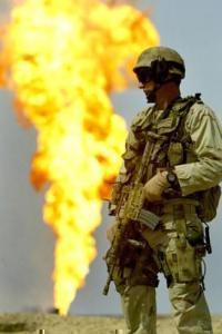 Американский морской пехотинец стоит на фоне горящей скважины
