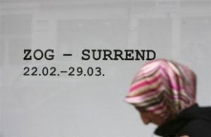 Мусульманка проходит мимо зала галереи, где выставляются провокационные плакаты датской группы Surrend