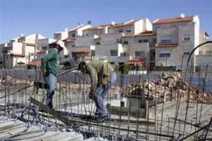 Рабочие на строительстве новых домов в еврейском поселении Ариель на Западном берегу  
