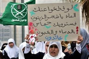 Иорданская женщина демонстрирует плакат с лозунгами в поддержку движения ХАМАС