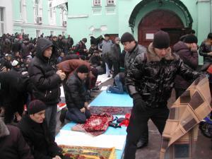 Люди, молящиеся во дворе Соборной мечети Москвы 