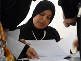 Жительница Кувейта изучает списки для голосования на избирательном участке в Салве, Кувейт. Фото AP