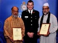 Мохаммед Чудари (справа) и Сирадж Вали получают грамоты от шефа полиции Джона Робинса за "да'ават"