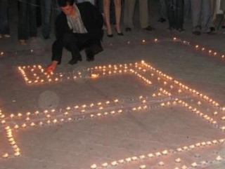 Из свечей участники акции выкладывают крымскотатарский национальный символ - тамгу крымских ханов Гераев