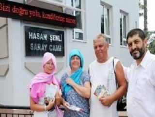 Имам мечети Сарай джами Ахмет Али Демирага с иностранными туристами, интересующимися исламом