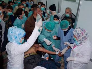 Медики оказывают помощь раненному в инциденте, в организации которого правительство и оппозиция обвиняют друг друга