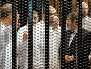 Мухаммад Мурси и его соратники в судебном заседании. ПРезидент, по прежнему, отказывается сменить свой костюм на тюремную робу, как это требуют правила суудебного процесса в Египте.