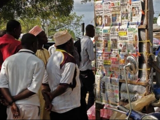 Жители Занзибара изучают заголовки газет после теракта