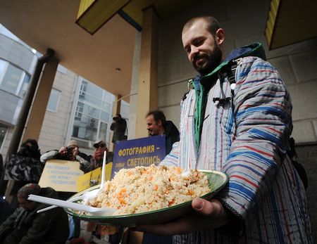 Мужчина несет блюдо с пловом во время празднования Курбан-байрама в Ижевске (Фото - ridus.ru) 