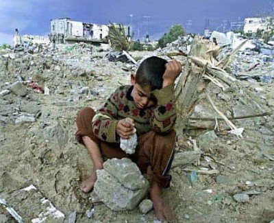 Палестинский мальчик сидит на руинах своего дома в секторе Газа 
