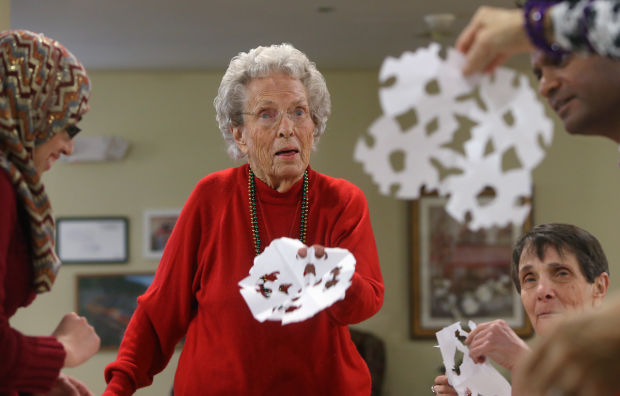 Мусульманки вместе с жительницами дома престарелых вырезают снежинки из бумаги