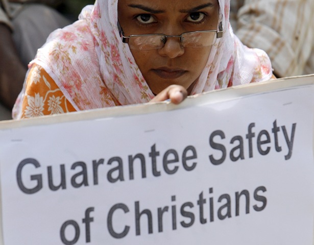 Христианка держит в руках плакат с требованием гарантировать безопасное Рождество