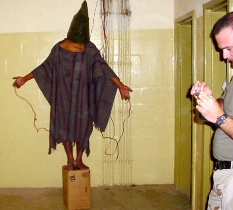 Американский военный пытает узника иракской тюрьмы Абу-Грейб