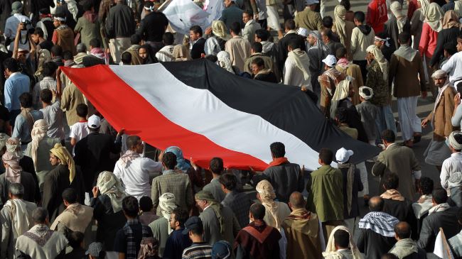 Сторонники «Ансаруллы» несут флаг Йемена во время акции протеста