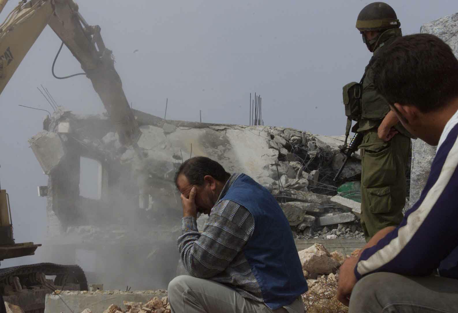 Палестинец плачет, наблюдая за тем, как израильский бульдозер уничтожает его дом, на месте которого будет построено жилье для еврейских поселенцев