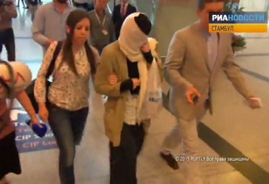 Караулова (в черной абаи и с прикрытым лицом) в аэропорту Стамбула на пути в Москву