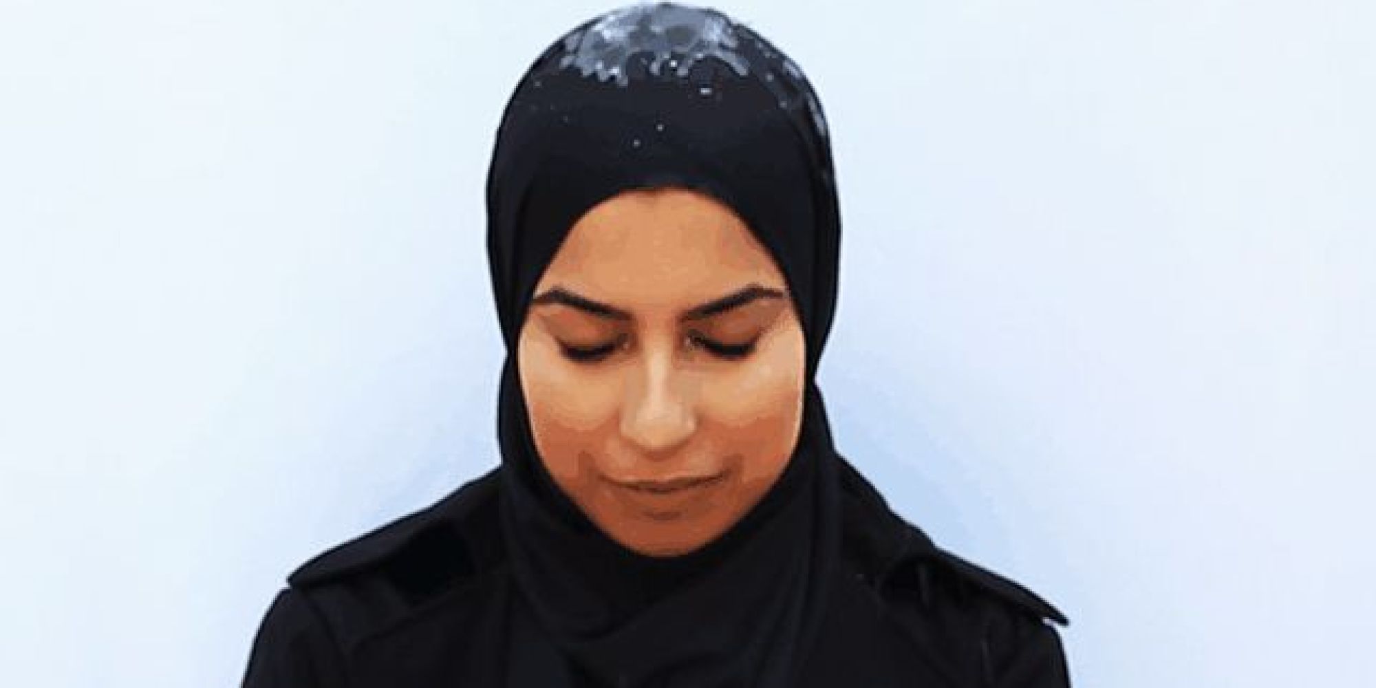На голову женщины в новом хиджабе льют воду, чтобы продемонстрировать, как она скатывается с поверхности и не впитывается