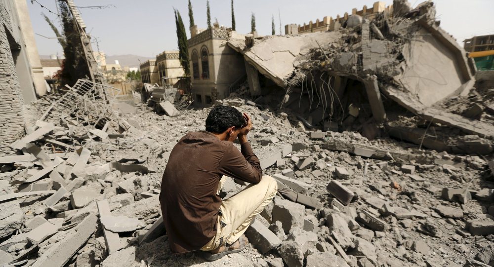 Житель Йемена возле дома, разрушенного в результате бомбардировок