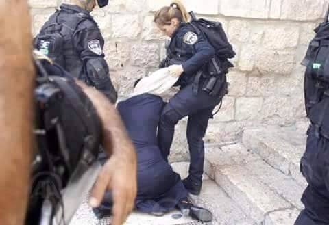 Сотрудница израильской полиции сдирает платок с палестинки