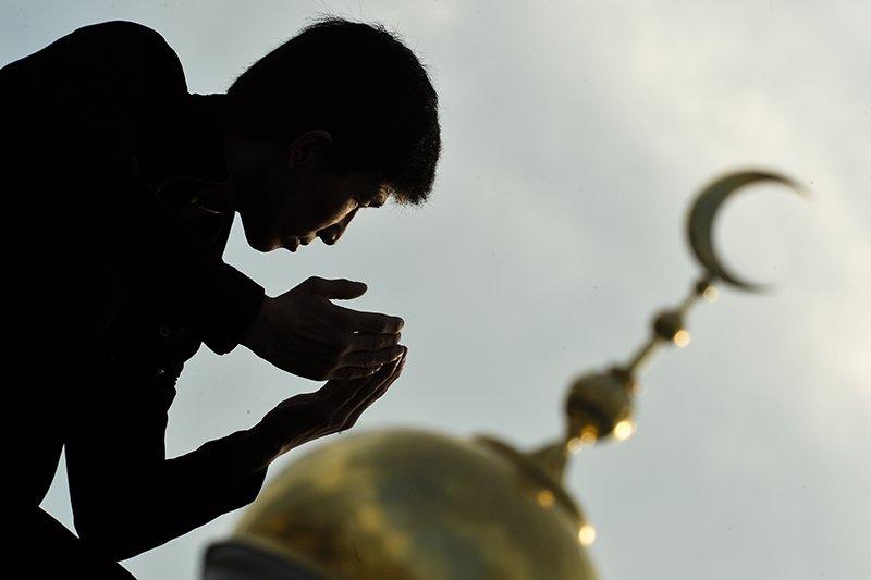 Мусульманин совершает молитву  в Курбан-байрам возле Соборной мечети Москвы