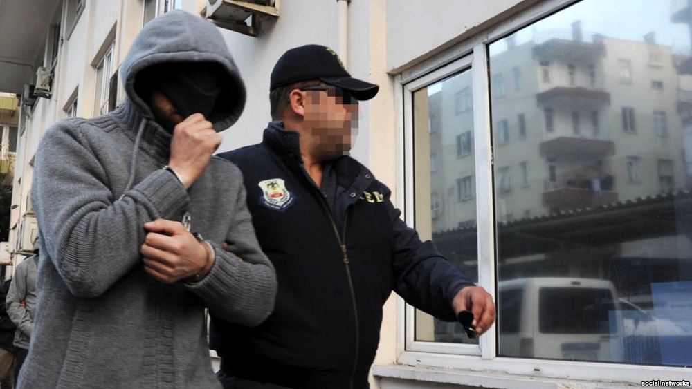На снимке, сделанном турецким журналистом, – полицейский сопровождает задержанного гражданина России