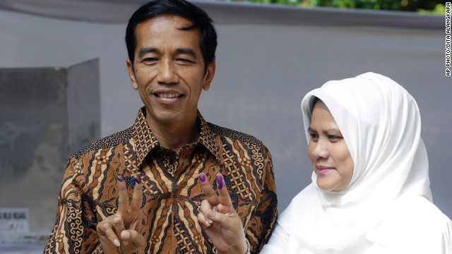 Indonesian presidential candidate Joko Widodo, popularly known as «Jokowi», left, and his wife Iriana, show their inked fingers after casting their ballots during the presidential election in Jakarta, Indonesia, Wednesday, July 9, 2014. (AP Photo/Dita Alangkara)