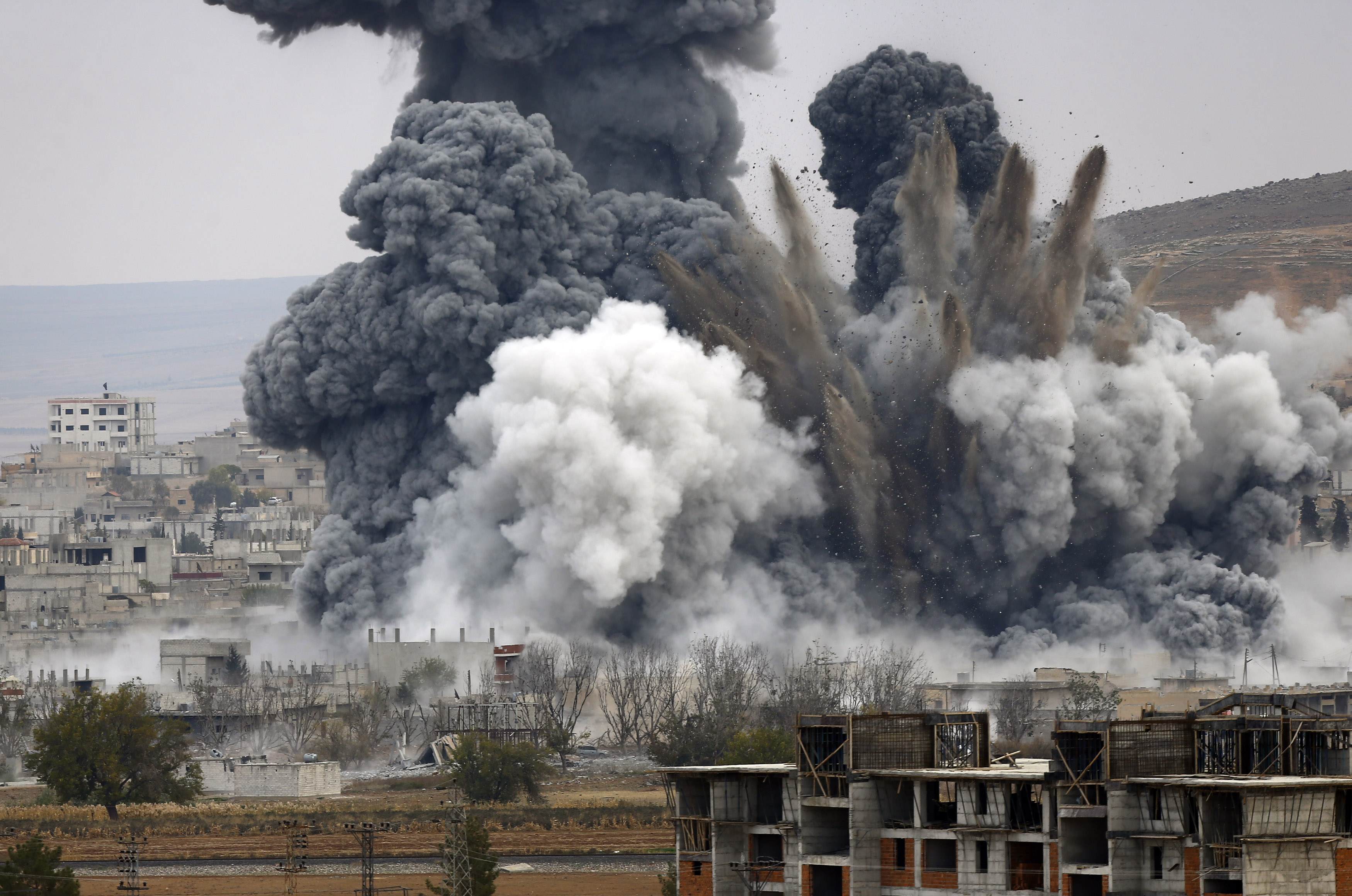 An explosion following an air strike is seen in central Kobani in Syria, November 17, 2014. Picture taken from the Turkish side of the Turkish-Syrian border. REUTERS/Osman Orsal (TURKEY - Tags: POLITICS MILITARY CONFLICT TPX IMAGES OF THE DAY)