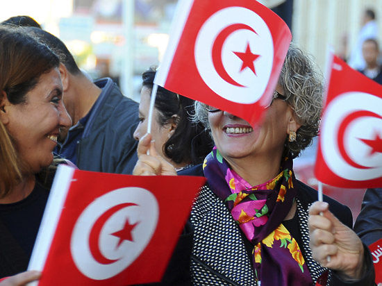 Женщины держат в руках флаги Туниса