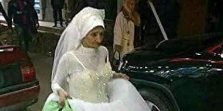 Бабушка в платье невесты идет по Александрии