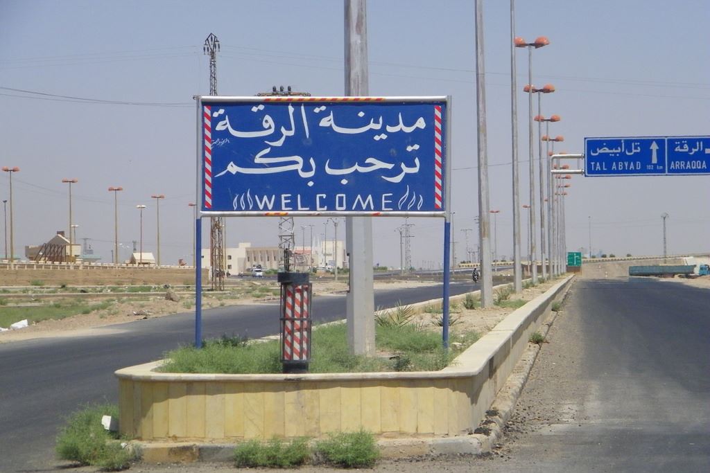 На вывеске: Добро пожаловать в город Ракку