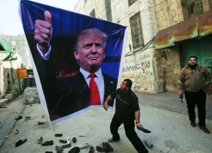 Палестинец бросает ботинок в портрет Трампа