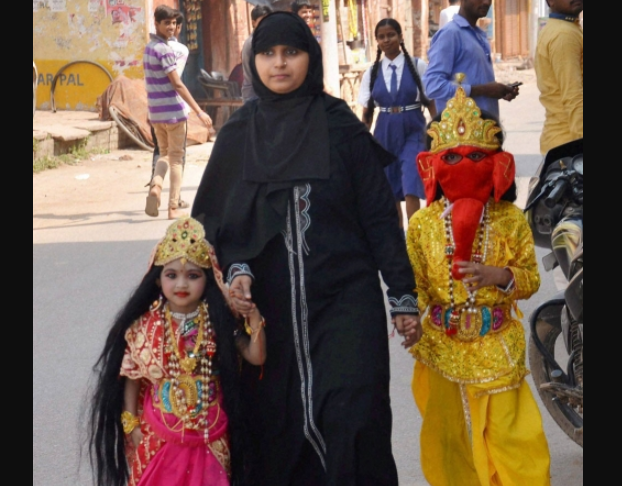 Мусульманка ведет за руки детей, одетых в костюмы индуистских божеств