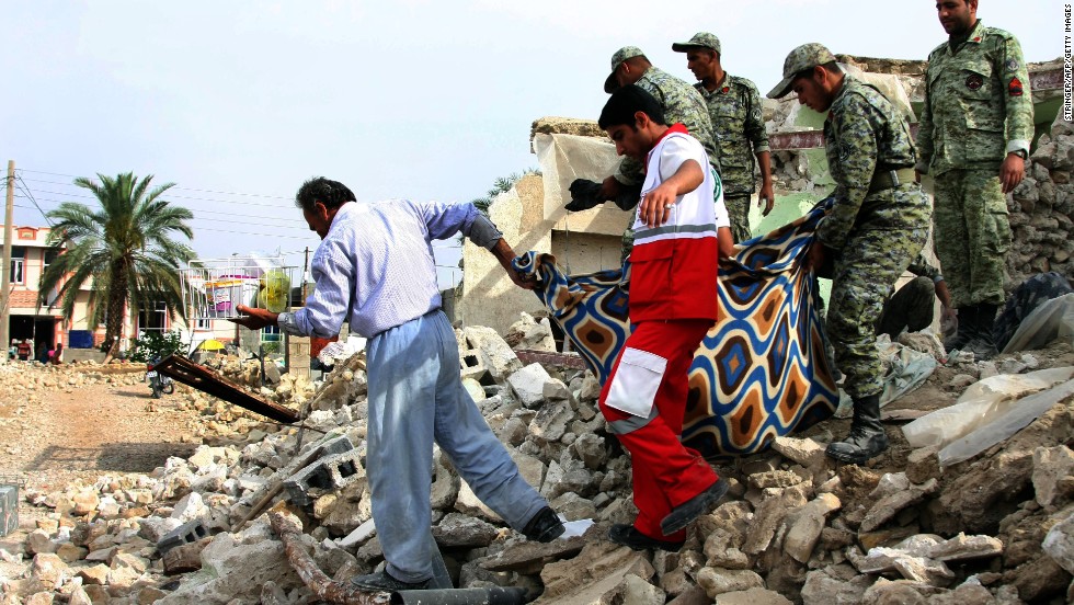 Иранские солдаты совместно со спасателями ищут людей под руинами разрушенных домов