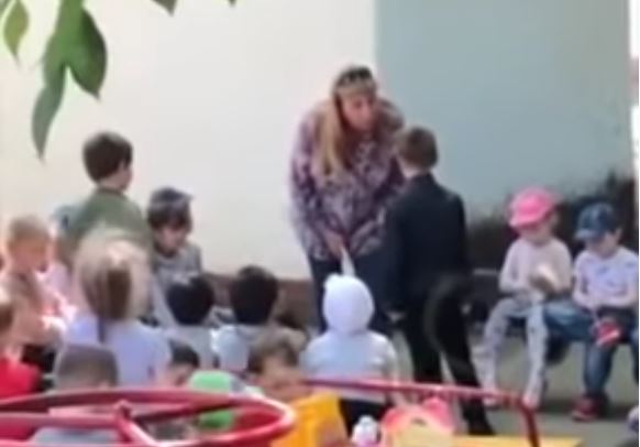 Воспитательница ставит мальчика на колени