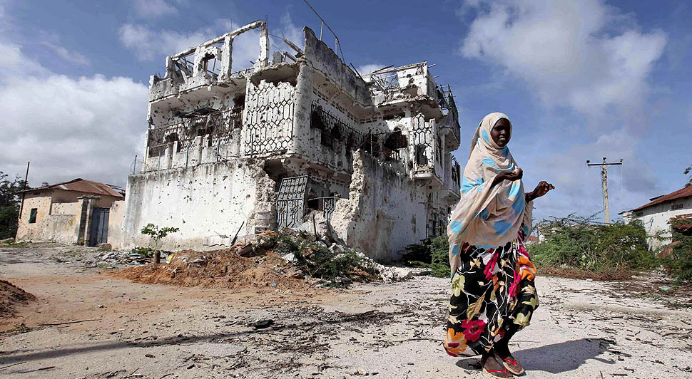 Жительница Сомали возле разрушенного дома