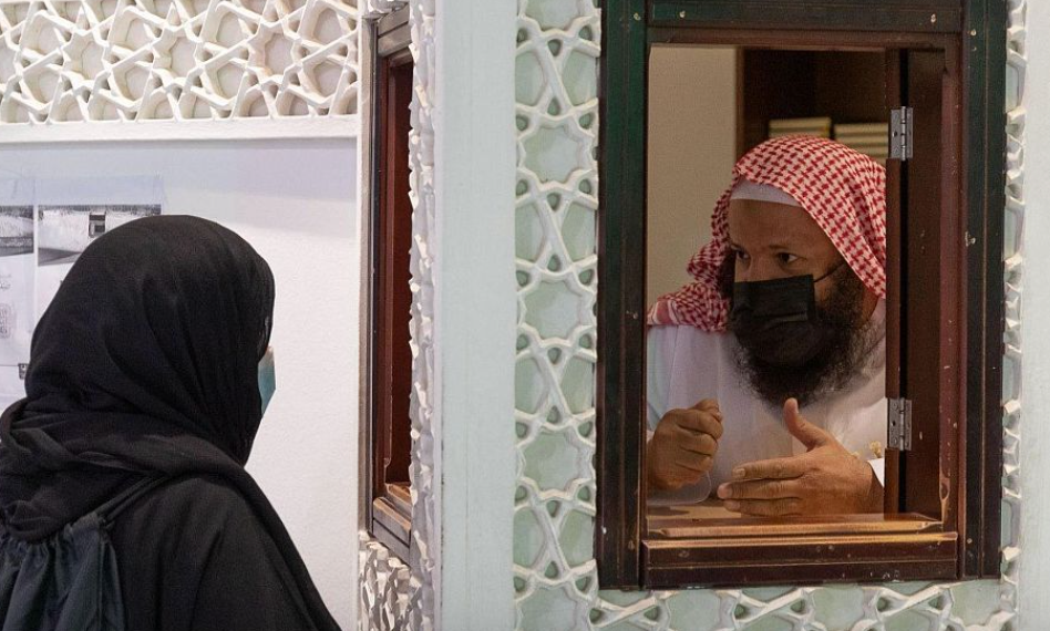 Ученый в кабинке отвечает мусульманке на религиозный вопрос
