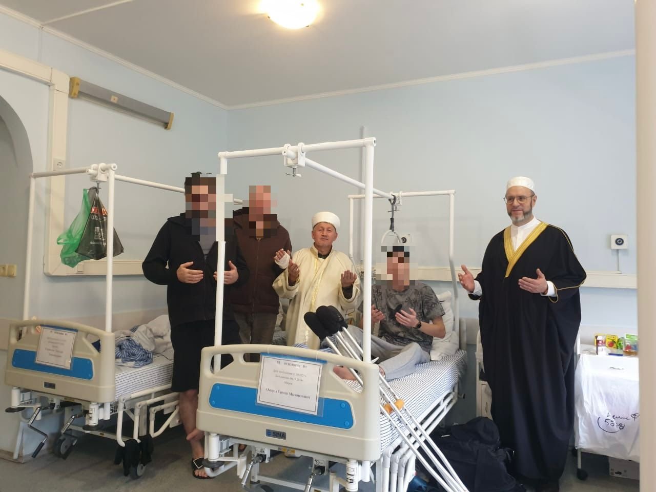 Имамы Московской Соборной мечети Райс Билалов (в черной мантии) и Марат Аршабаев во время очередного визита к участникам СВО