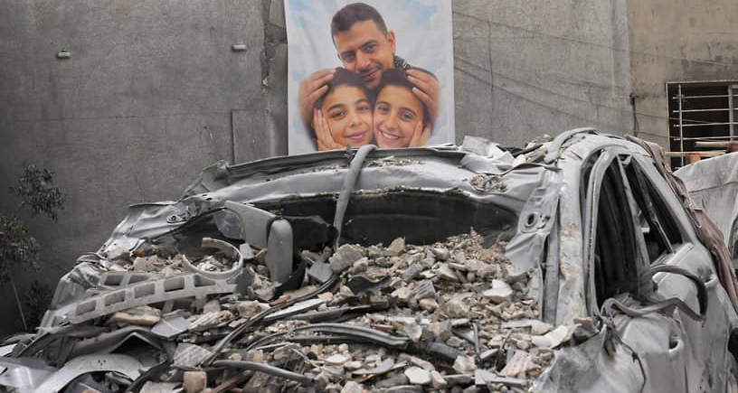 Фотография мужчины с детьми, погибших при обстреле Израиля  Фото: Hussein Malla / AP