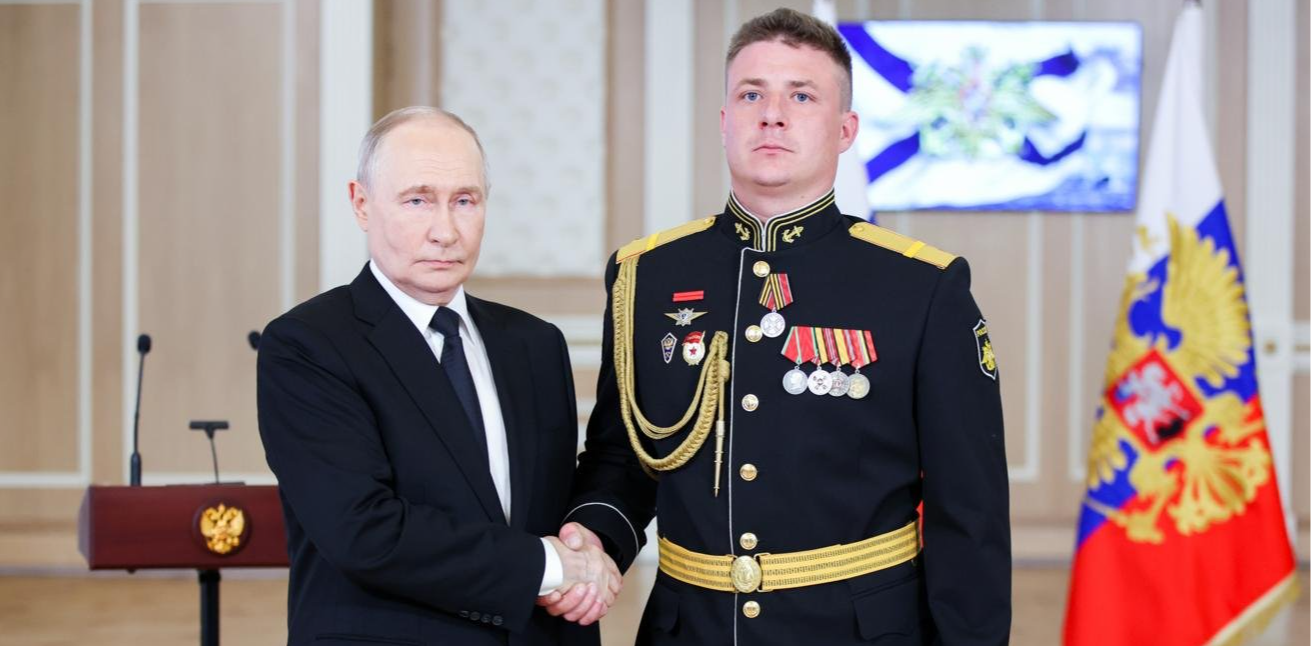 Президент РФ Владимир Путин и гвардии старший матрос морской пехоты Каспийской флотилии Виталий Сучков  © Петр Ковалев/ ТАСС